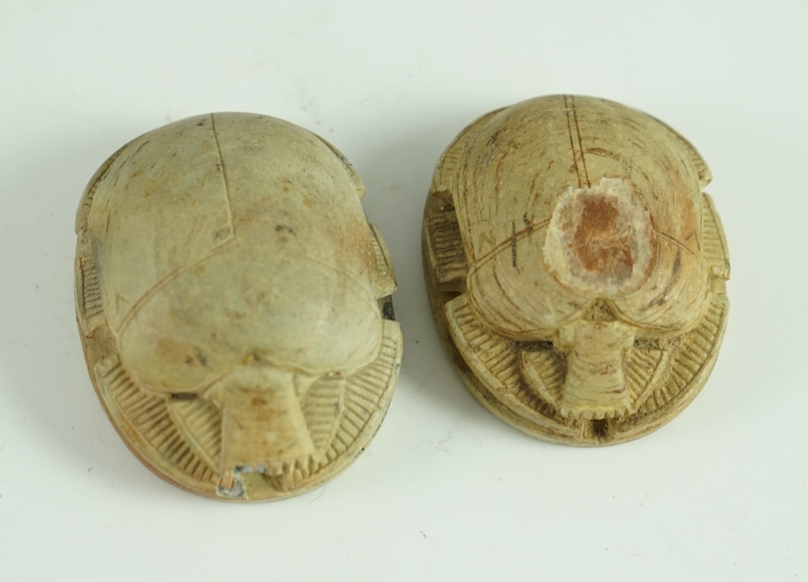 A group of antiquities comprising two commemorative scarabs, an Egyptian style gypsum head, and two antique terracotta heads